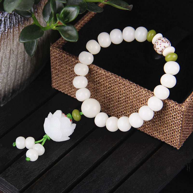 Lotus White Seed Bracelet – Polished bodhi beads with green jade accents on woven display, mindfulness jewelry