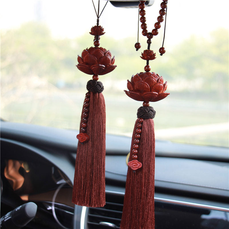 Red Sandalwood Lotus Tassel - two ornaments on car rearview mirror with outdoor bokeh, auspicious
