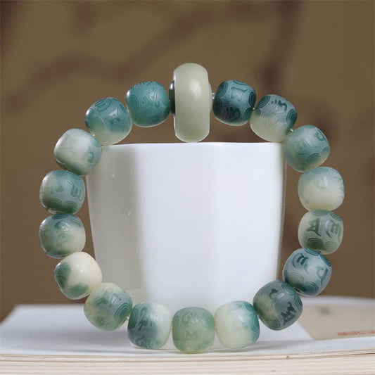 Bodhi Seed Om Mani Padme Hum Bracelet – Close-up of carved teal beads with cream guru bead, prayer bead bracelet