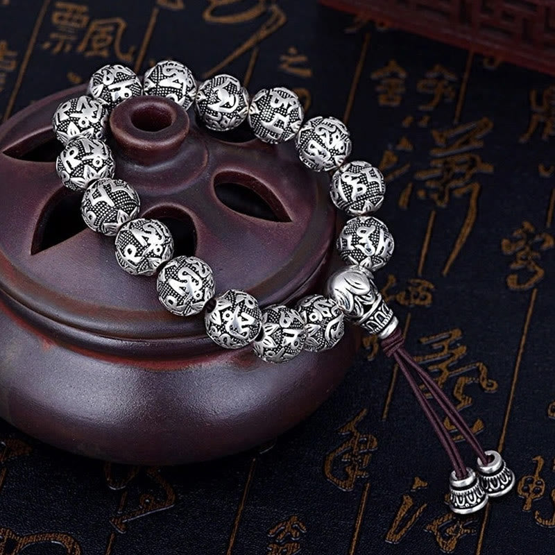 Om Mani Padme Hum Bracelet – Silver beads on incense burner with gold calligraphy backdrop