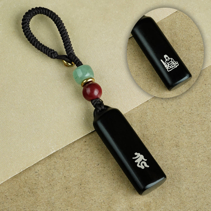 Ebony Eight Guardians talisman keychain hanging from car key with jade and cinnabar bead accents