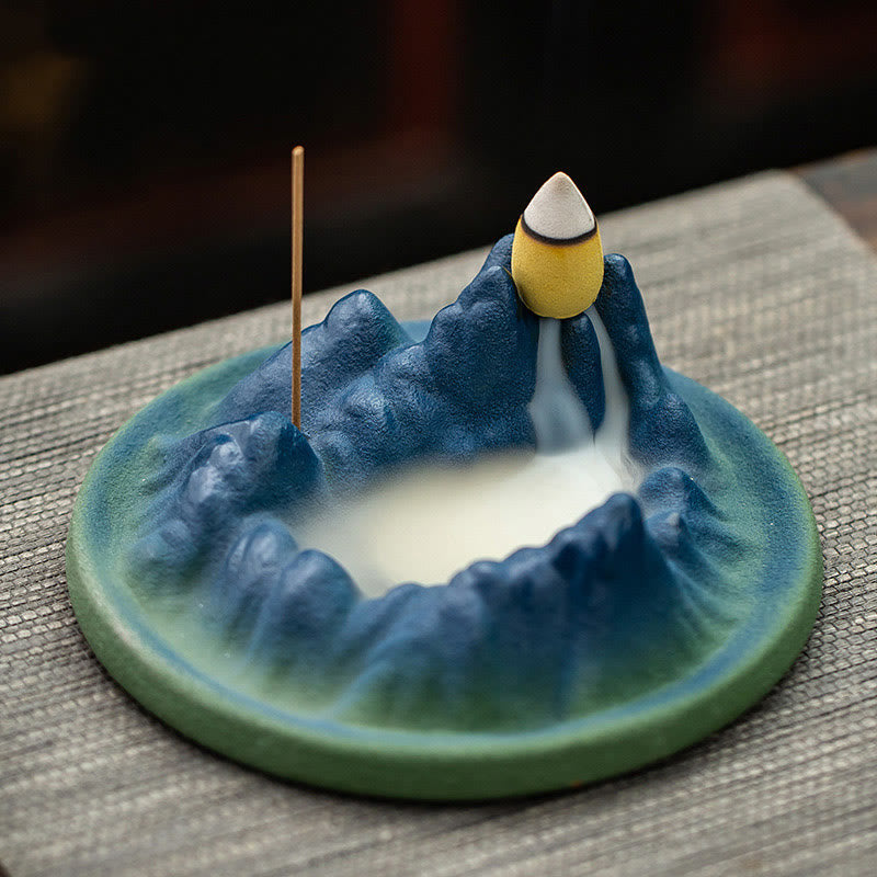 Ceramic Backflow Incense Burner – Teal mountain crater with white smoke waterfall on gray mat, meditation decor