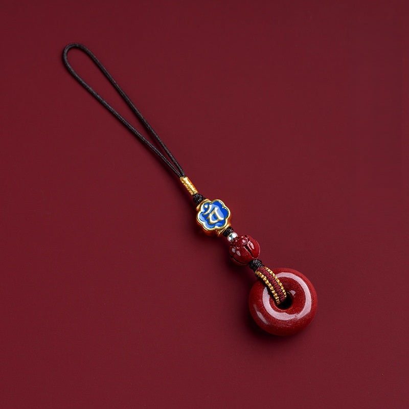Natural cinnabar zodiac amulet with blue enamel zodiac bead on dark red background