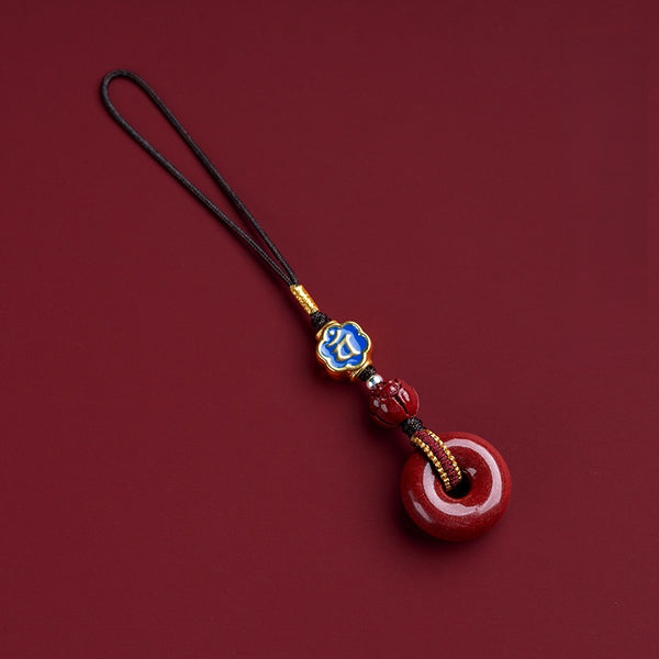 Natural cinnabar zodiac amulet with blue enamel zodiac bead on dark red background