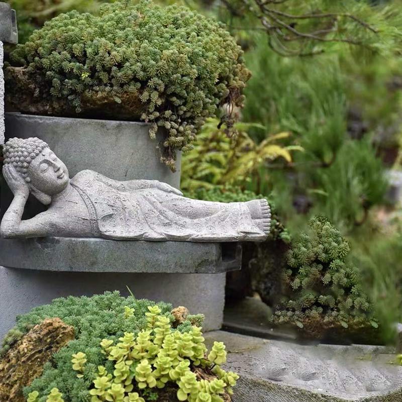 Tibetan Meditation Buddha Resin Decoration – reclining Buddha statue on tiered stone among succulents, outdoor meditation scene, Zen
