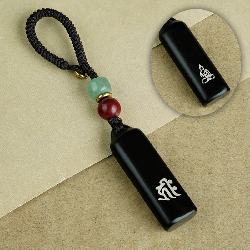 Ebony Eight Guardians talisman keychain product shot on pure white background with silver Buddha inlay