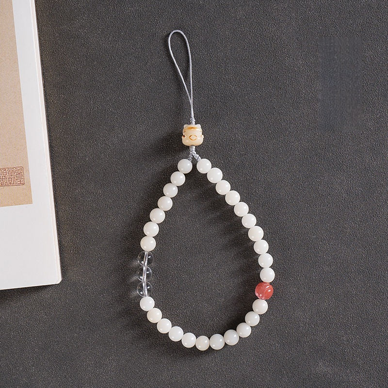 White Jade Bodhi & Jadeite Crystal Phone Charm – White bodhi beads with clear quartz, pink stone, and double cat paw dangles on gray background