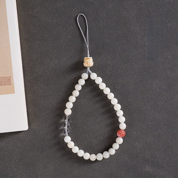 White Jade Bodhi & Jadeite Crystal Phone Charm – White bodhi beads with clear quartz, pink stone, and double cat paw dangles on gray background