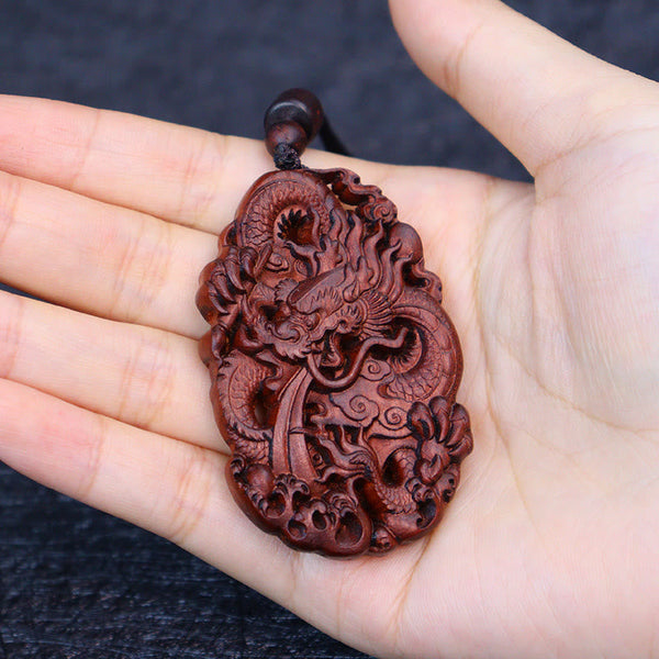 Lightning Jujube Wood Dragon Pendant - Palm-held on dark textured fabric, carving depth, Gift