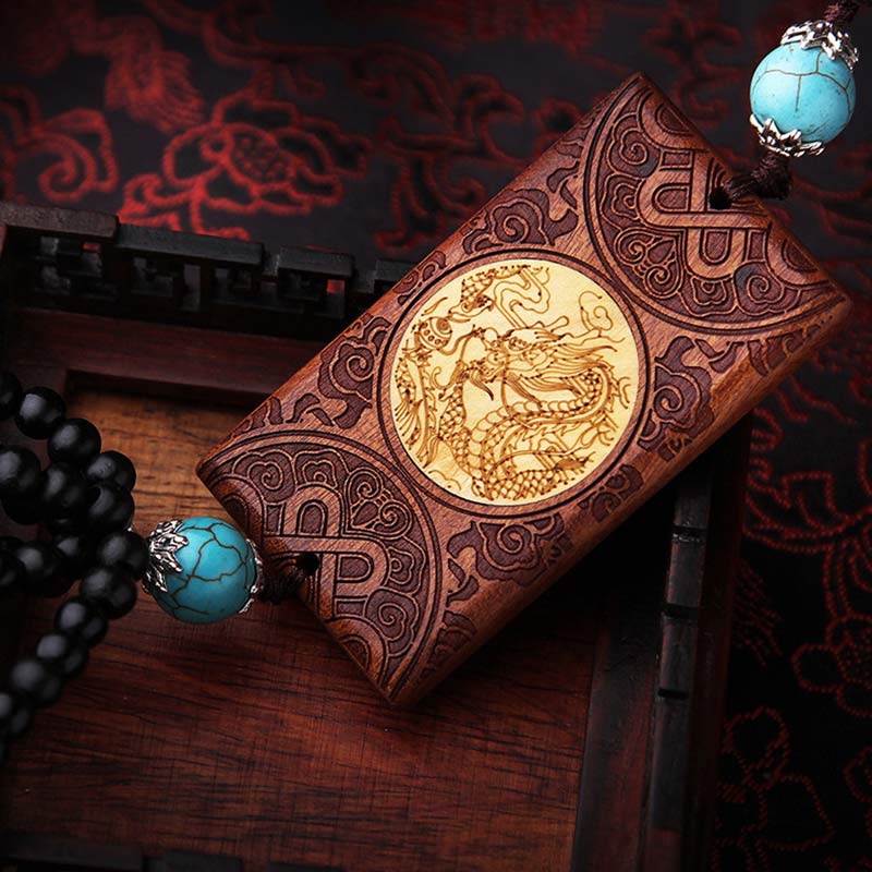 Rosewood Dragon Decoration – diagonal overhead view with turquoise beads and black bead tassel, Luck