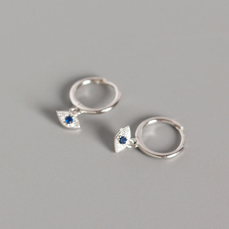 Silver Evil Eye Stud Earrings with Blue Center Stone on Gray Background, Evil Eye Charm