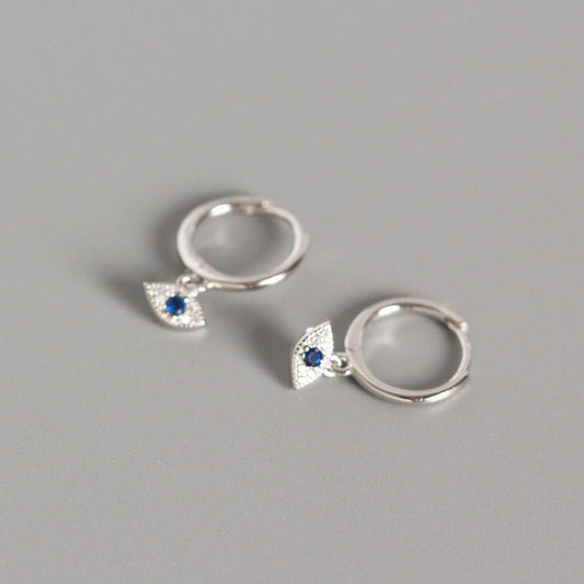 Silver Evil Eye Stud Earrings with Blue Center Stone on Gray Background, Evil Eye Charm