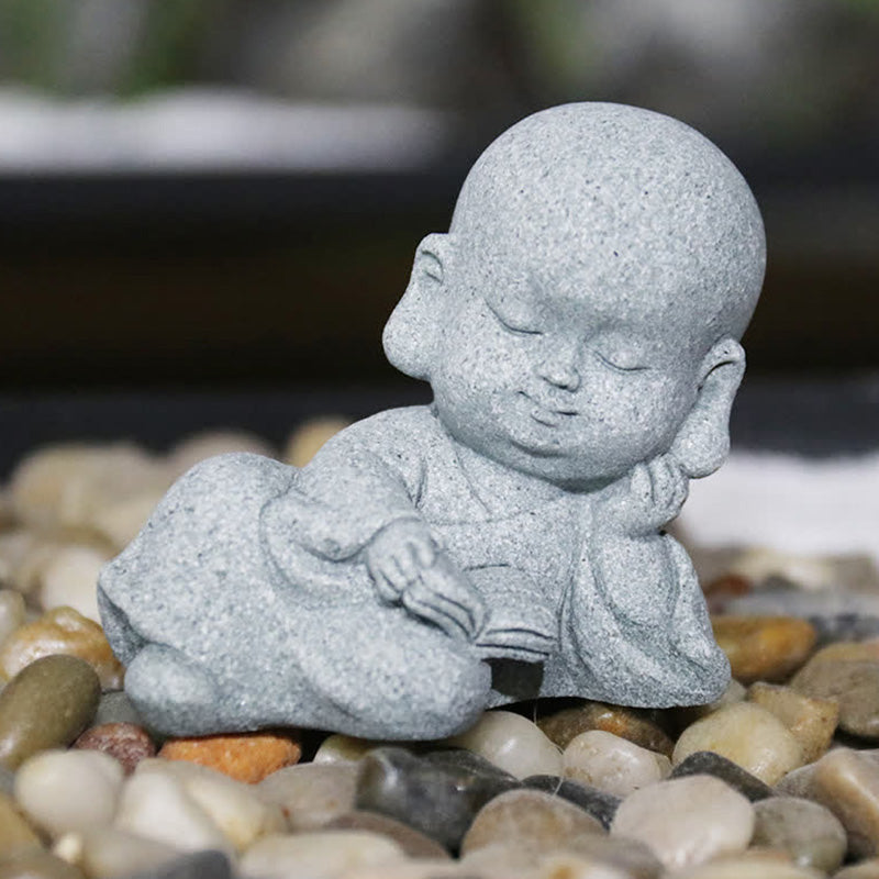 Meditation Monk Statue - Baby monk lying down reading book on pebbles, zen garden decor