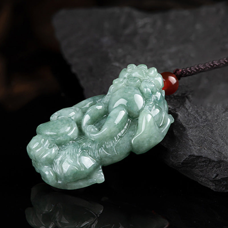 Jade PiXiu Necklace – Green jade Pixiu on reflective black surface with red bead accent, prosperity pendant
