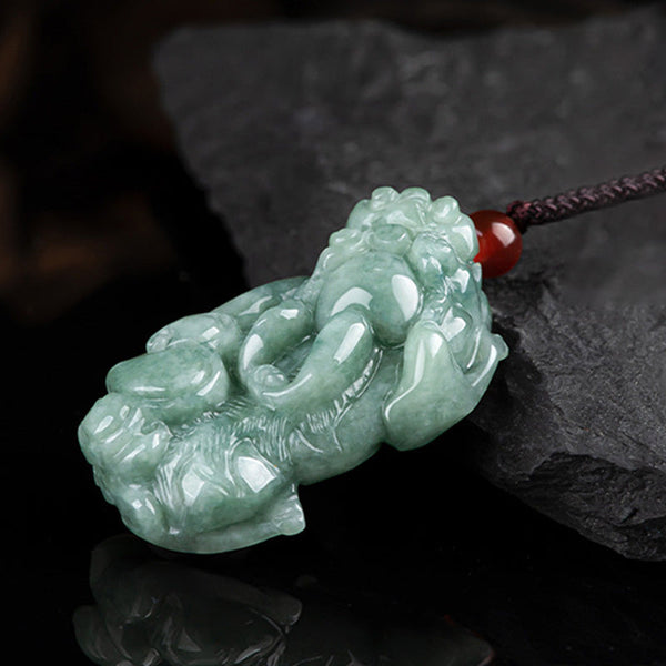 Jade PiXiu Necklace – Green jade Pixiu on reflective black surface with red bead accent, prosperity pendant