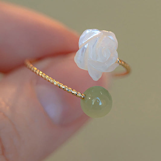 14K Gold Tridacna Jade Rose Ring – Gold twisted wire band with white shell rose and green jade bead, macro close-up on beige bokeh background