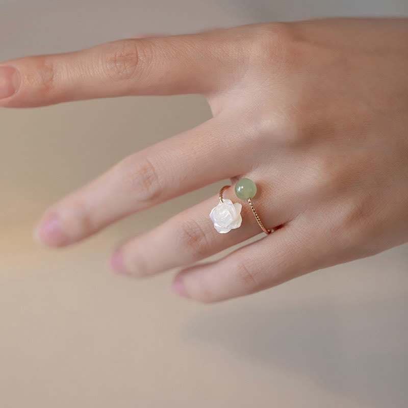 14K Gold Tridacna Jade Rose Ring – Gold twisted wire open ring with white carved rose and green jade worn on finger, beige neutral background lifestyle