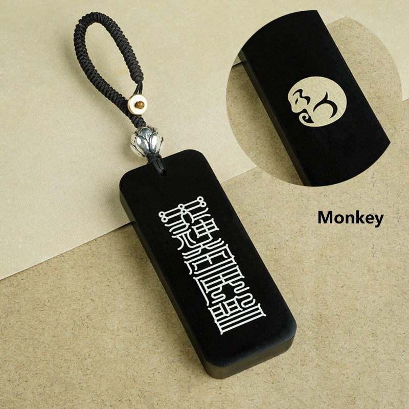 Ebony zodiac keychain material detail showing copper inlay versus silver inlay and dimensions 25x60x8mm