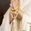 Bodhi Seed Lotus Dzi Bracelet - Hands in prayer pose with cream beads and green jade ring, bodhi seed