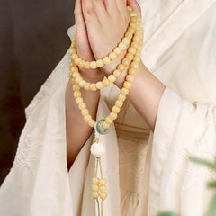 Bodhi Seed Lotus Dzi Bracelet - Hands in prayer pose with cream beads and green jade ring, bodhi seed