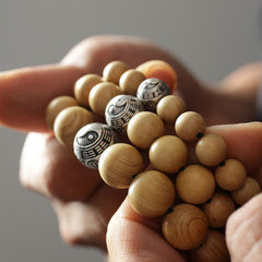 Peach Wood Cinnabar Bracelet – Three yin yang bagua metal beads held in cupped hands, luck protection