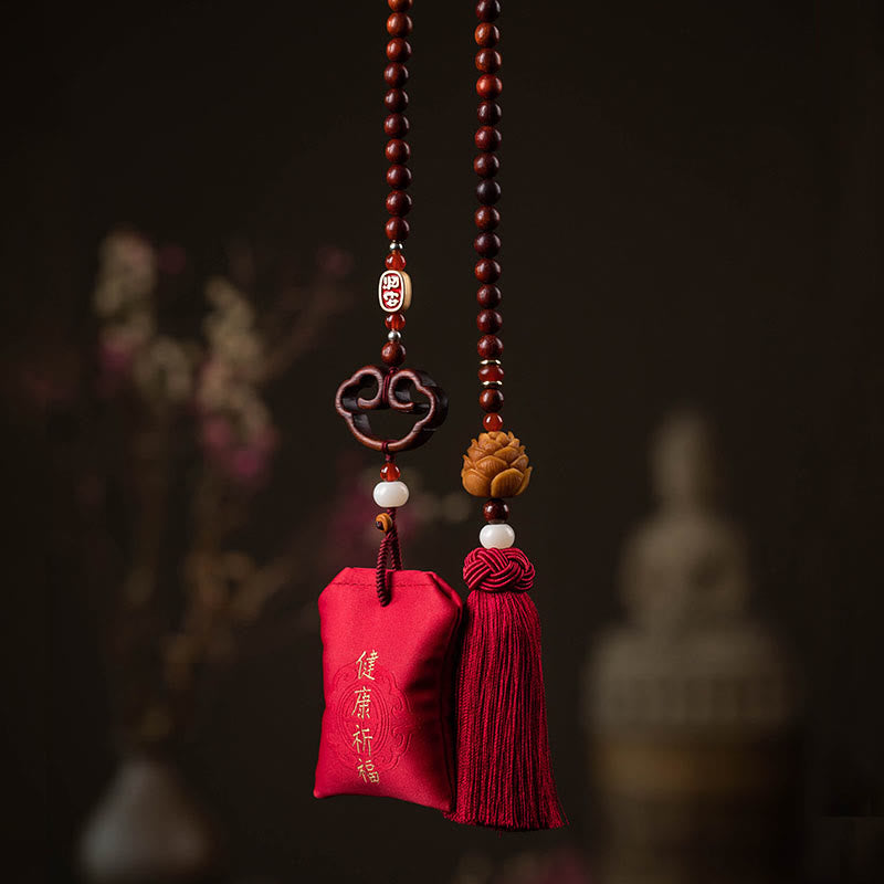 Red Sandalwood Car Hanging – Health blessing pouch and lotus tassel on dark wood beads with blurred traditional interior