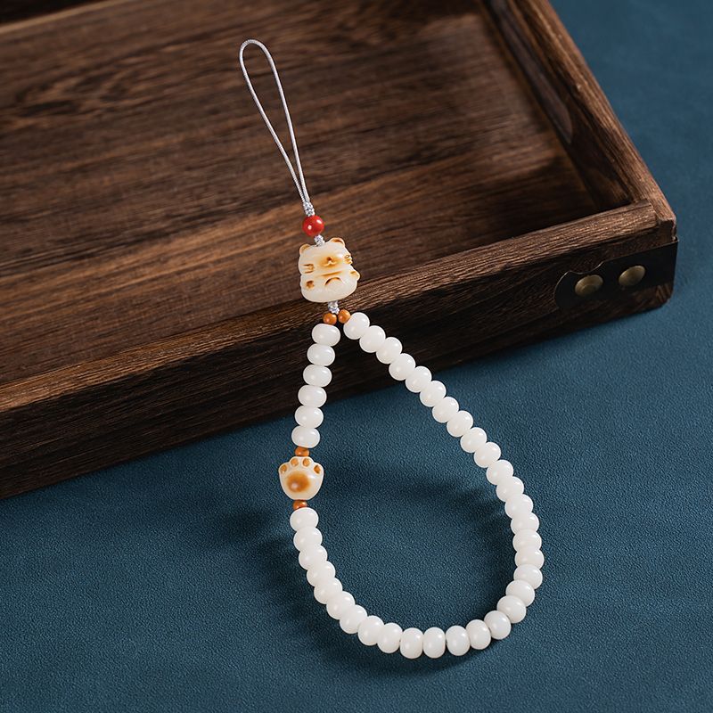 White Jade Bodhi & Jadeite Crystal Phone Charm – White beads with cat paw charms and red accent bead on blue fabric and wood tray