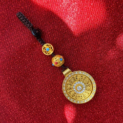 Gold auspicious disc keychain with diamond inlay and turquoise accents on brown cord