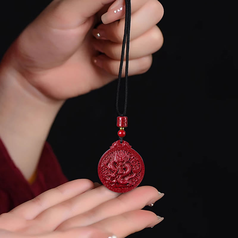 Cinnabar Dragon Pendant – Hands holding vermillion dragon amulet on black cord, Personal