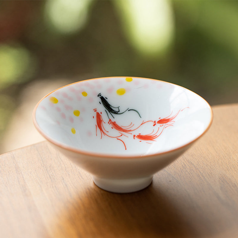 Mandala Koi Teacup – Overhead flat lay beside tea leaves and bamboo mat