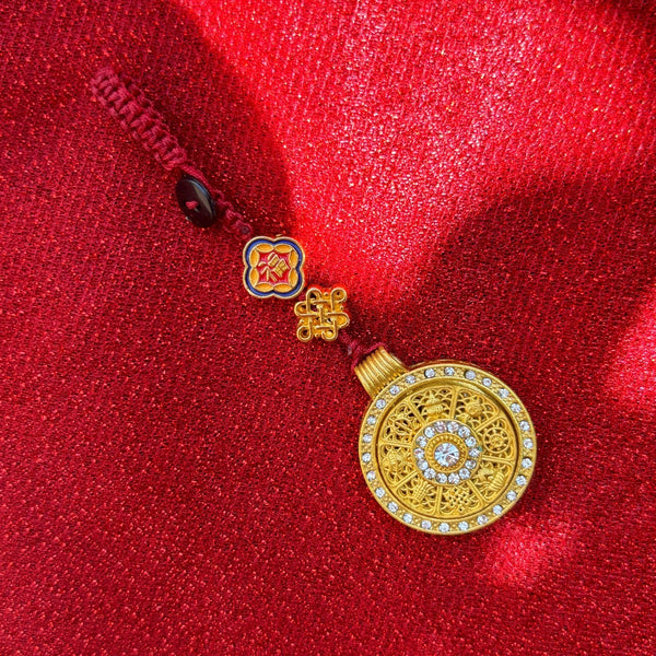 Gold enamel calabash keychain with ruyi pattern, gold cord on pink fabric