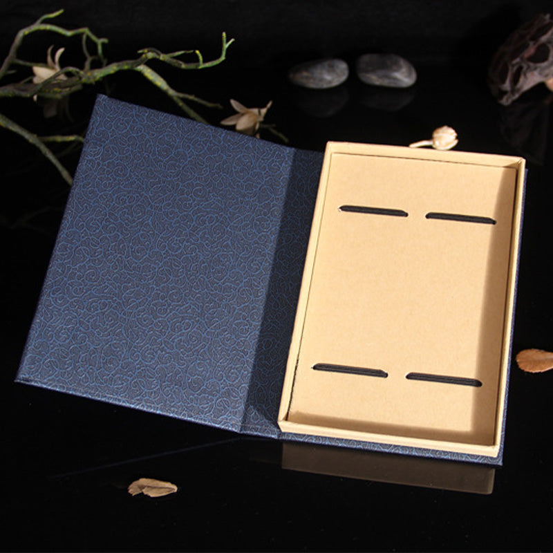 Tree of Life Wood Bookmarks - empty navy brocade gift box with elastic bands on reflective black surface