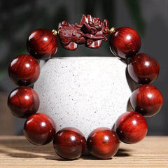 Red Sandalwood PiXiu Bracelet – Deep red polished wood beads with carved PiXiu on white ceramic cup, zen