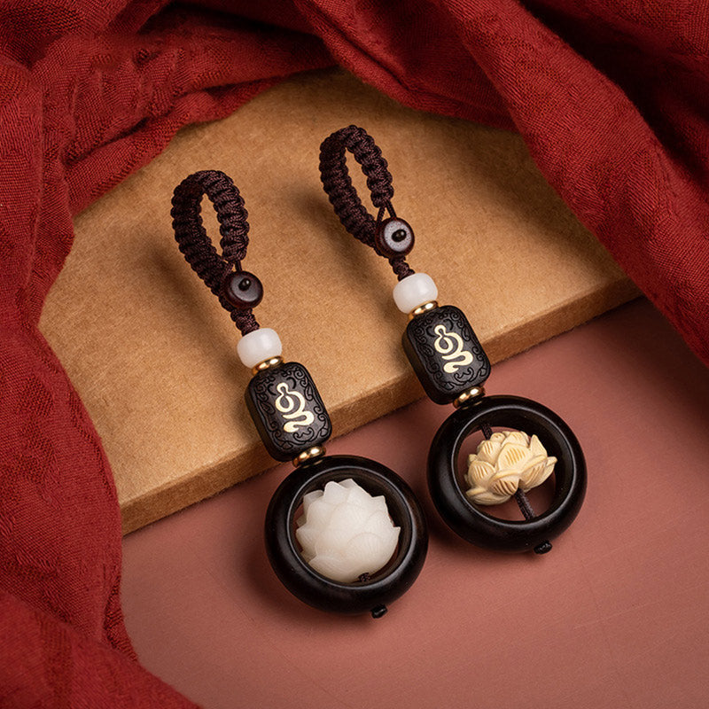 Ebony Wood Bodhi Seed Lotus Key Chain - two lotus color variants on burgundy fabric