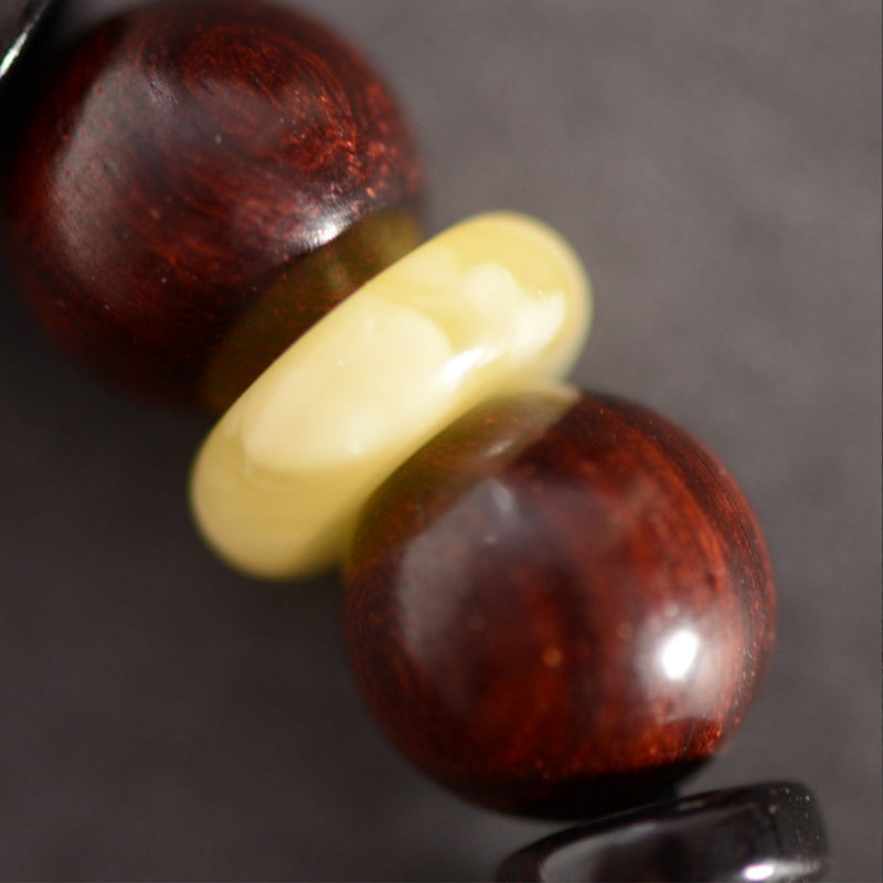 Red Sandalwood Om Bracelet – close-up of polished red wood beads with cream spacer, natural sandalwood texture detail