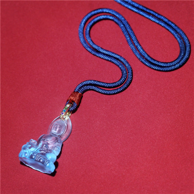 Blue Tathagata Medicine Buddha Liuli Crystal Necklace – flat-lay diagonal view on crimson surface, dark blue braided cord with multicolor woven knot section