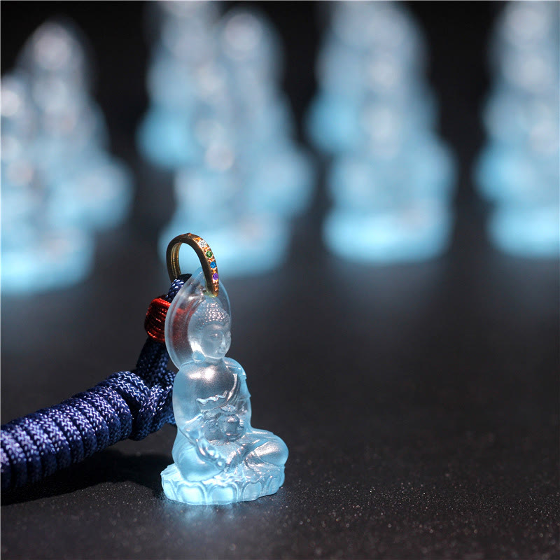 Blue Tathagata Medicine Buddha Liuli Crystal Necklace – frosted blue Buddha pendant with speckled braided cord and gem-set gold bail, dark backdrop with bokeh repeats