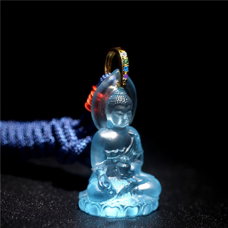 Blue Tathagata Medicine Buddha Liuli Crystal Necklace – aquamarine translucent Buddha pendant on dark cord, rainbow gemstone bail, black backdrop glow