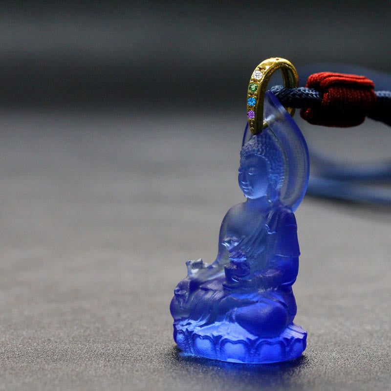 Blue Tathagata Medicine Buddha Liuli Crystal Necklace – deep blue pendant on dark blue cord with red knot, pebbled leather surface, gemstone-accented gold bail close-up