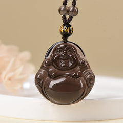 Black Obsidian Buddha Necklace – pendant held to lamp showing ice obsidian transparency, quality test