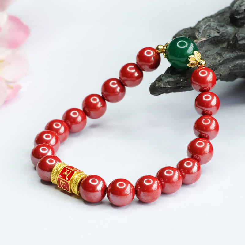 Cinnabar Agate Bracelet – Resting on dark stone prop with flowers, beaded bracelet