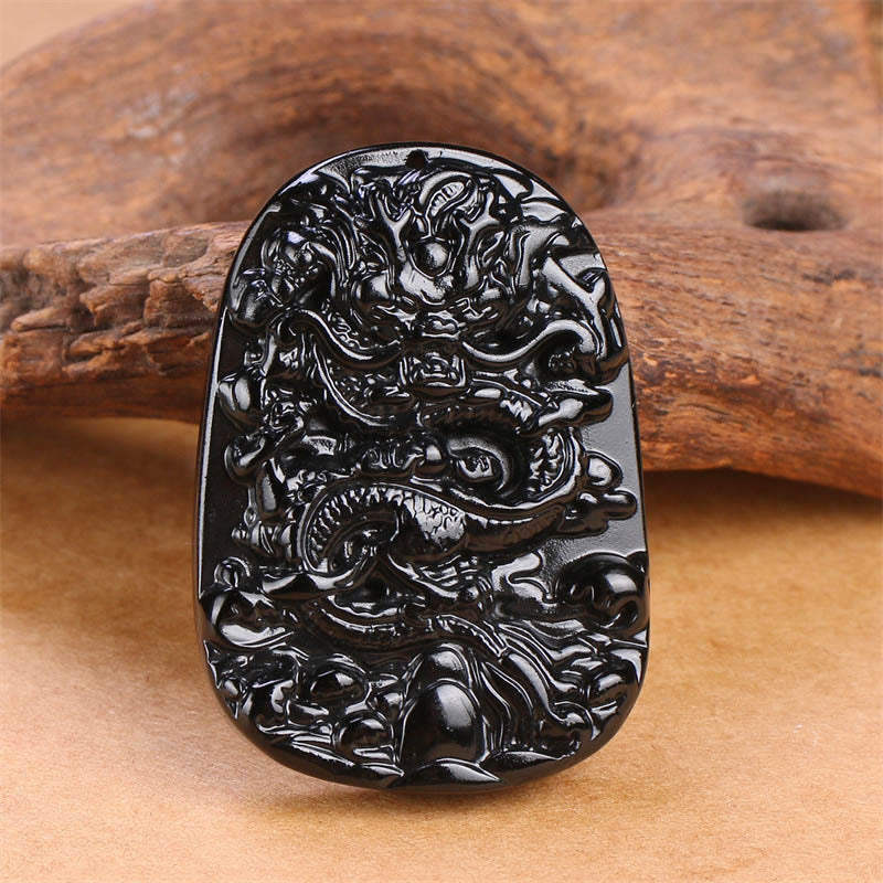 Black Obsidian Dragon Carved Pendant – Frontal relief dragon carving on weathered wood, spiritual craftsmanship