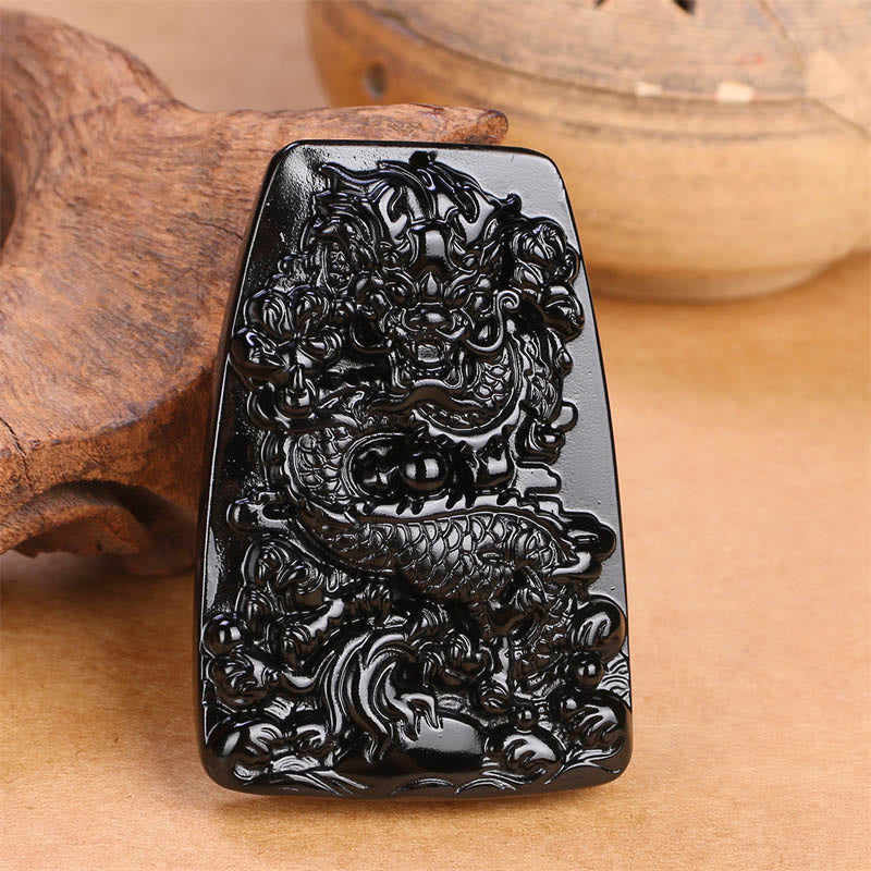 Black Obsidian Dragon Carved Pendant – Standalone carved tablet on wood with ceramic prop, traditional