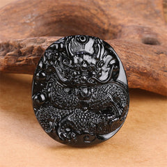 Black Obsidian Round Dragon Pendant – oval dragon relief on warm wood with earthy tones, traditional