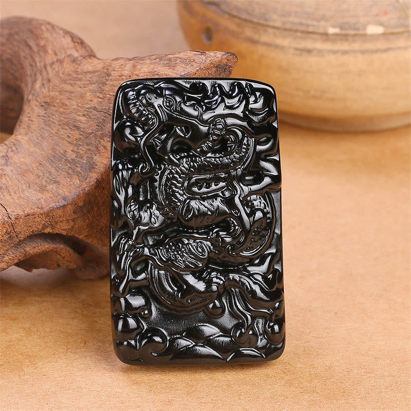 Black Obsidian Dragon Pendant – standalone rectangular plaque on weathered wood with ceramic pot, traditional