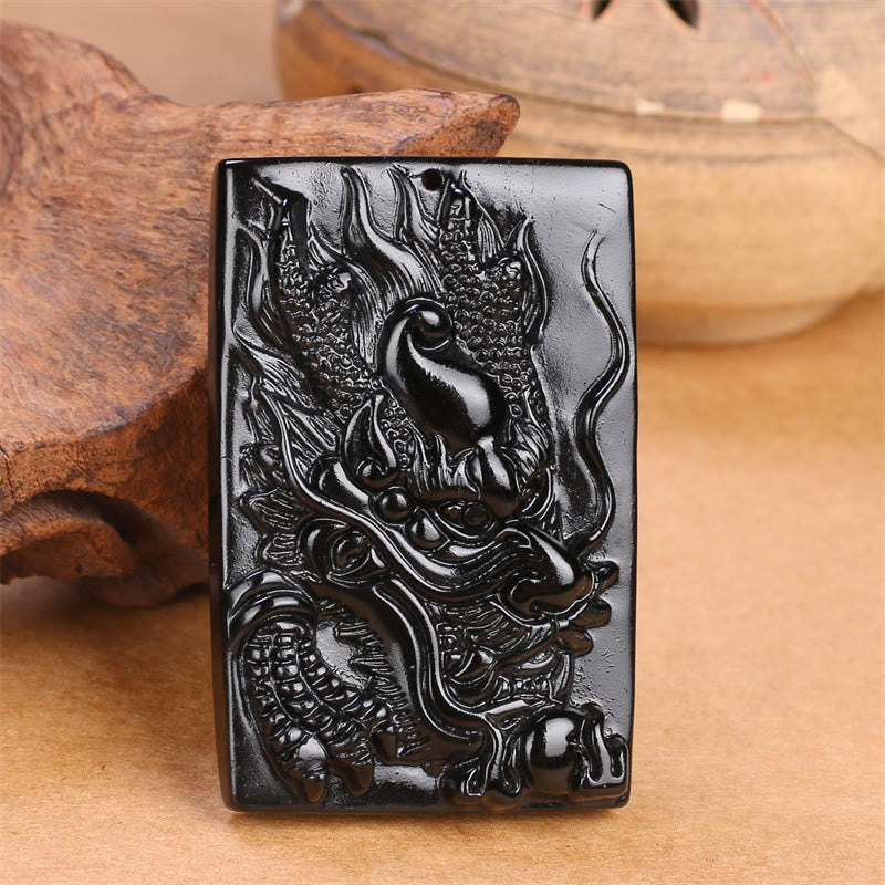 Black Obsidian Dragon Pendant – flat lay cord necklace with amber beads on natural linen, earthy