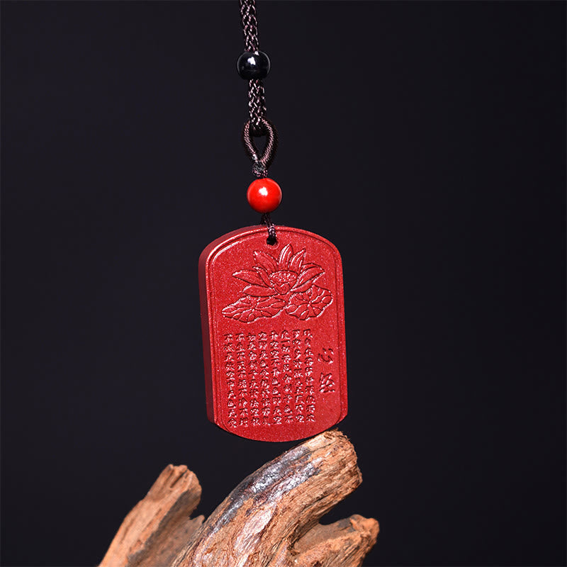 Cinnabar Lotus Pendant Necklace – front view on driftwood with braided cord and red bead, Buddhist amulet