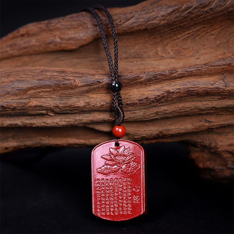 Cinnabar Heart Sutra Necklace – full front view on aged wood showing carved lotus and scripture, red talisman