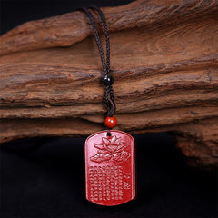 Cinnabar Heart Sutra Necklace – full front view on aged wood showing carved lotus and scripture, red talisman