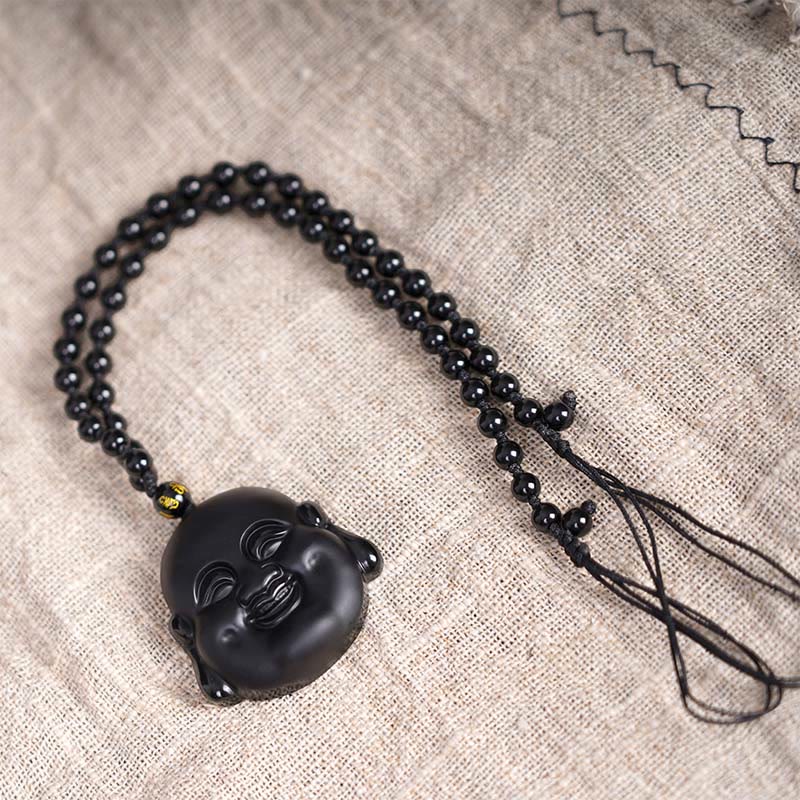 Black Obsidian Laughing Buddha Pendant Necklace Protection – wooden surface soft lighting, mindfulness meditation gift